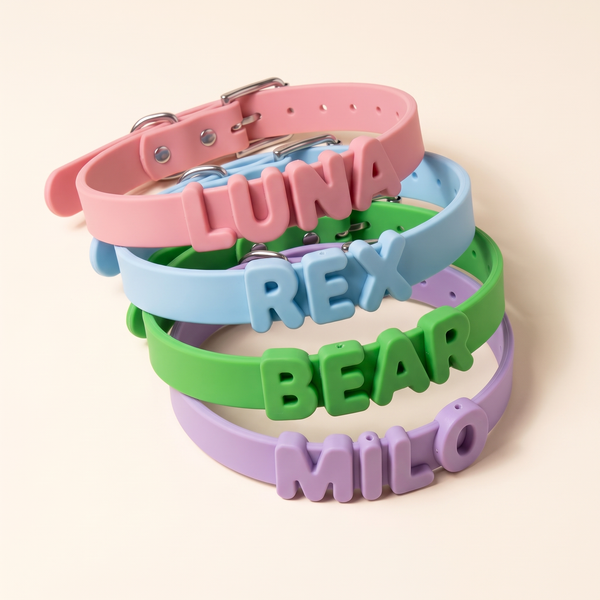 Four silicone name collars stacked – pink, blue, green and purple