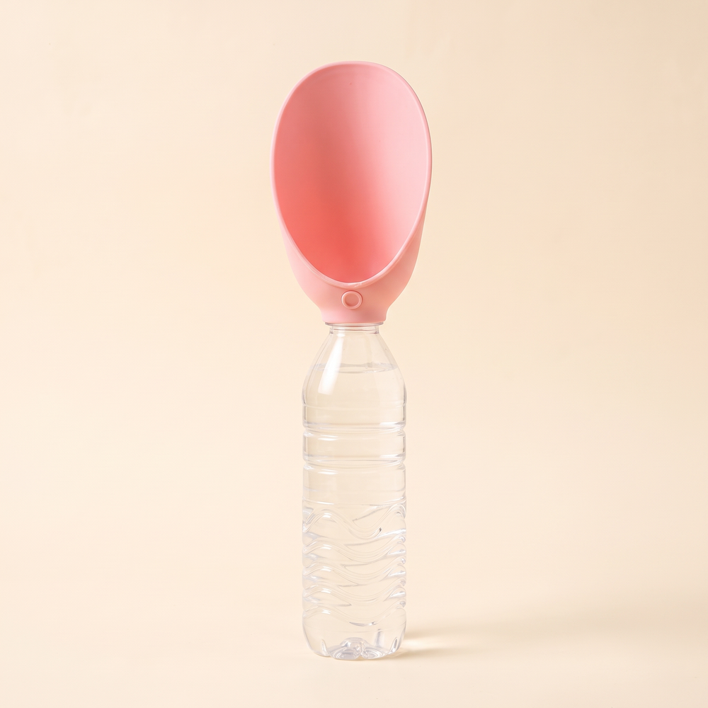 Pink silicone dog drinking tray opened as a scoop on top of the bottle