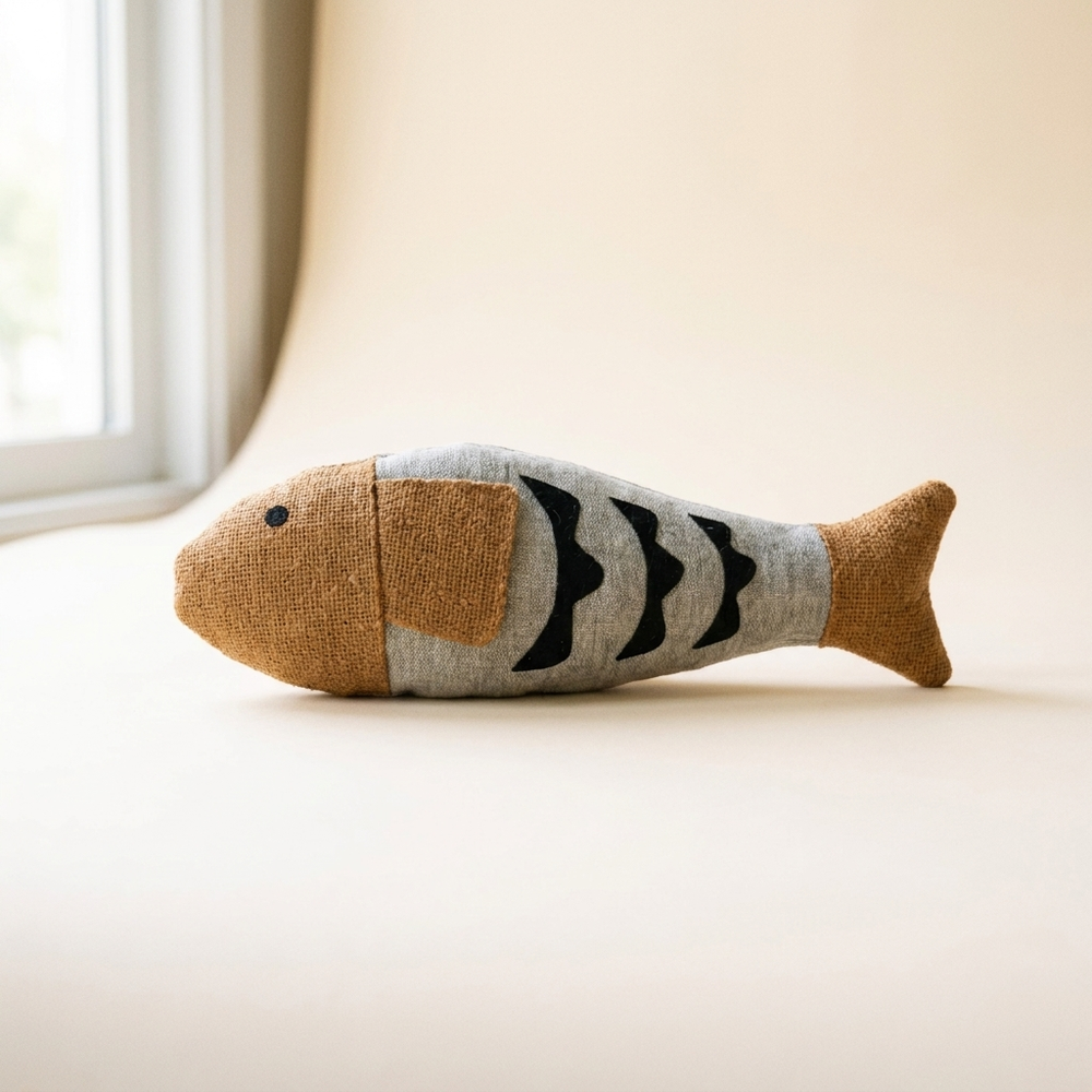 Crinkle fish cat kicker toy with bell on cream studio background