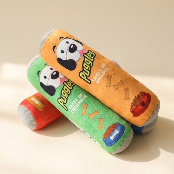 Squeaky cartoon plush dog toy on cream studio background