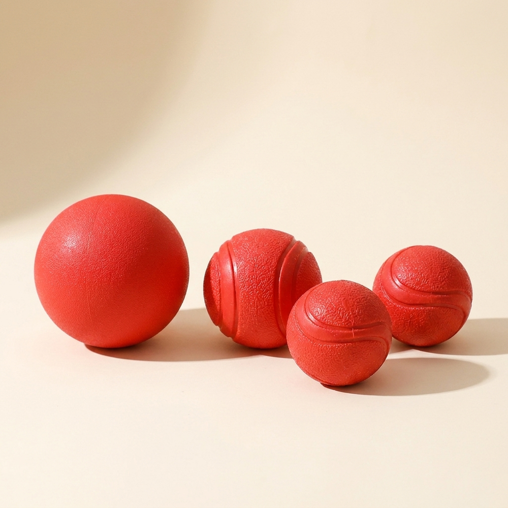 Ultra durable rubber bouncy ball dog toy on cream studio background