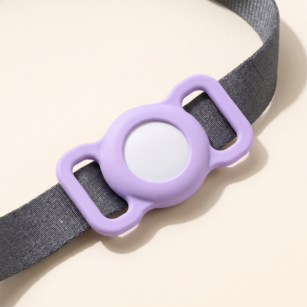 Purple silicone AirTag collar case attached to a dog collar, studio product photo