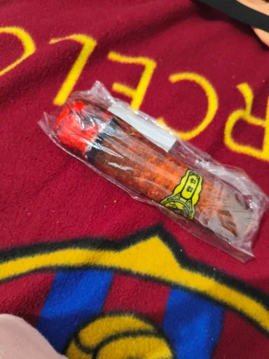 Customer photo: cigar-style plush dog toy held in hand