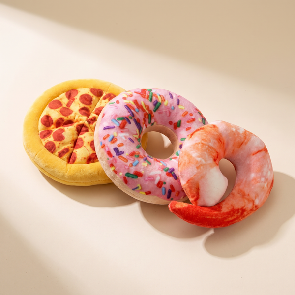 Squeaky plush pizza, doughnut and shrimp dog toys together